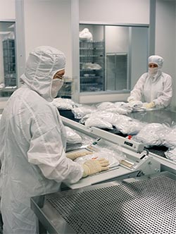 Workers wearing cleanroom garments in sterile facility